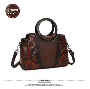 Detailed relief of sunflower and leaves on brown leather bag with wooden handle