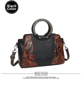 Detail view of black vintage tote bag with embossed sunflower pattern and wooden handles