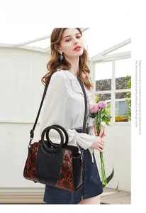 Detail of vintage tote bag featuring floral embossing and round wooden handle