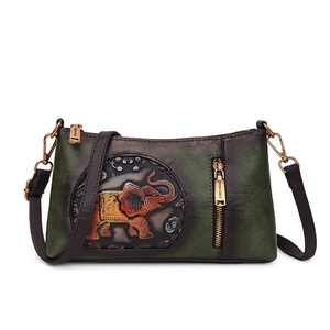 Vintage green leather crossbody bag with embossed elephant pattern and adjustable strap