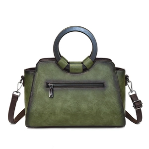 Vintage green leather tote bag with unique circular wooden handles and brown shoulder strap
