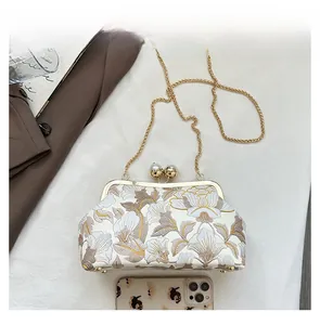 Détail du sac brodé à motif floral avec fermoir perle et bandoulière en chaîne