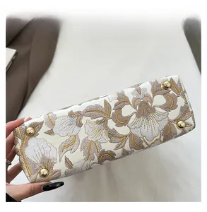 Détail de la base du sac jacquard avec quatre pieds de protection en métal doré