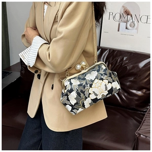 Détail du sac brodé noir vintage avec cadre doré et grand fermoir en perle luxe