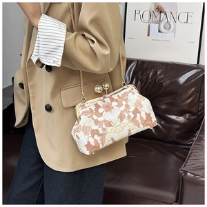 Détail du sac à broderie florale vintage avec fermoir perle et bandoulière dorée