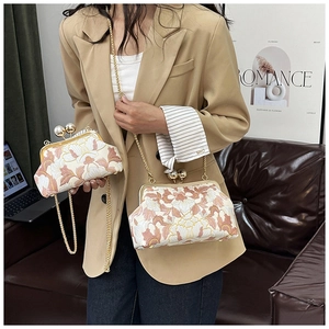 Détail du sac brodé de fleurs vintage avec fermoir perle et bandoulière chaîne dorée