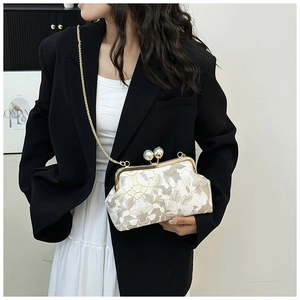 Détail de la broderie florale et du grand fermoir perle sur ce sac à bandoulière