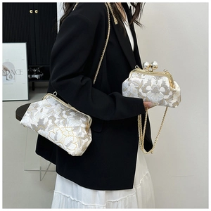 Détail de sacs bandoulière brodés de fleurs avec fermoir perle et bandoulières dorées