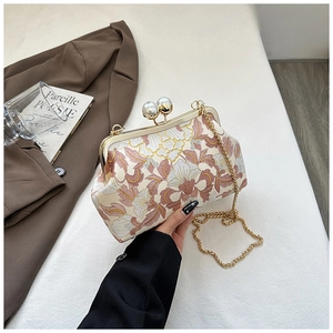 Vue détaillée de la broderie florale et du fermoir perle d'un sac de soirée vintage