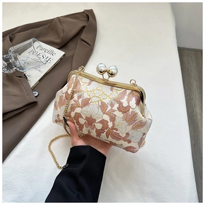 Détail de broderie florale sur sac vintage avec fermoir perle et bandoulière chaîne dorée