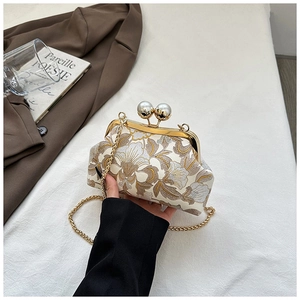 Détail d'un sac brodé vintage avec motifs floraux, fermoir perle et fine chaîne dorée