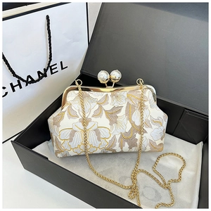 Détail de sac rétro brodé de fleurs avec fermoir perle présenté dans son coffret cadeau