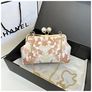 Vue détaillée d'un sac brodé vintage avec fermoir perle dans un coffret cadeau chic
