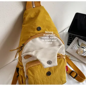 Détail du sac bandoulière en nylon jaune moutarde avec boucle magnétique et zips
