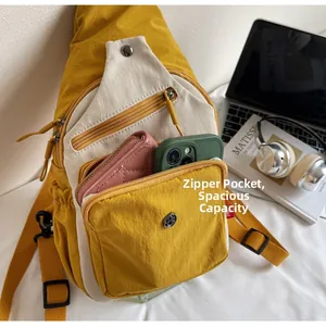 Détail d'un sac bandoulière en nylon avec compartiments multi-zippés pour objets du quotidien