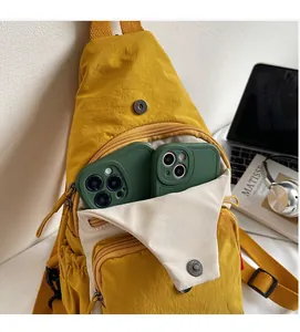 Détail du sac bandoulière en nylon jaune avec plusieurs poches et rabat avant magnétique