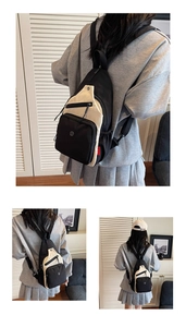 Détail du sac à bandoulière bicolore noir et blanc avec étiquette latérale rouge et logo