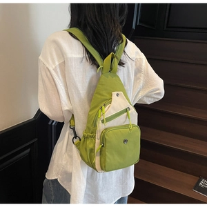 Détail du sac bandoulière en nylon bicolore vert et beige avec deux poches zippées devant
