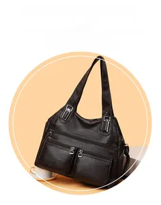 Détail d'un sac bandoulière vintage en cuir marron foncé avec doubles poches zippées devant