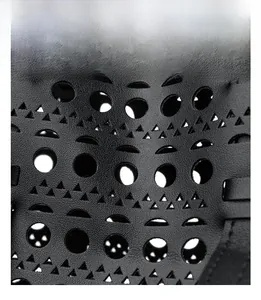 Detail of laser-cut geometric hollow texture on black premium leather tote bag