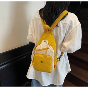Vue détaillée du sac à dos contrasté jaune avec poches zippées et étiquette latérale