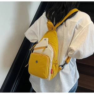 Détail du sac à bandoulière jaune et blanc avec fermetures éclair et poche latérale