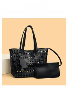 Close-up of black cutout bucket bag featuring a matching zipper pouch and cat charm