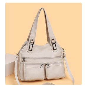 Gros plan du sac en similicuir beige avec texture litchi et multiples poches zippées