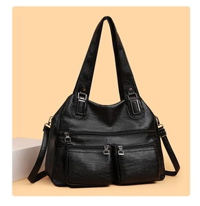 Détail d'un sac à bandoulière en cuir synthétique noir avec poches zippées et garnitures argentées