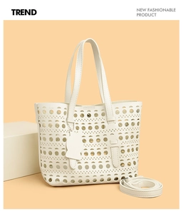 Detail of white laser-cut cutout tote bag featuring a cute cat-shaped leather charm
