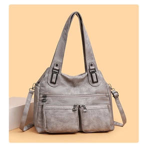 Gros plan d'un sac bandoulière gris vintage avec plusieurs poches et texture en cuir lavé