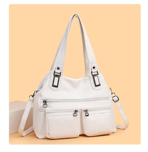 Détail d'un sac cabas blanc en similicuir avec trois poches zippées et ferrures argentées