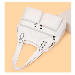 Détail d'un sac à main blanc en cuir souple avec plusieurs fermetures éclair et boucles