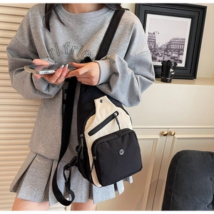 Détail d'un sac de poitrine noir et blanc décontracté avec sangle réglable et logo en métal