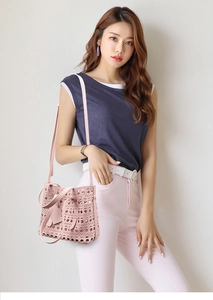 Detail of laser-cut geometric pattern on light pink hollow-out tote bag with inner pouch