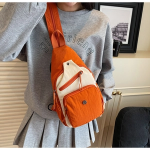 Détail du sac bandoulière nylon orange et beige avec poches zippées et sangle large
