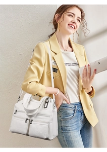 Détail d'un sac blanc multi-poches porté avec une tenue de travail élégante