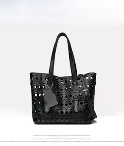 Detailed front view of black laser-cut tote bag with cat pendant and adjustable strap