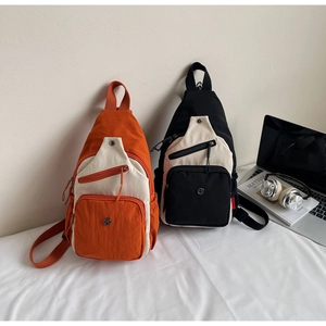 Détail de sacs bandoulière tendance en nylon orange et noir avec accessoires de mode