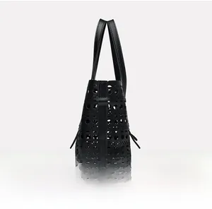 Side view of black cutout leather tote bag with modern geometric laser-cut hollow design