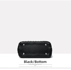 Detailed bottom view of black leather bucket bag featuring four silver metal protective feet