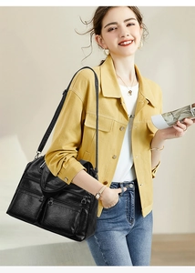 Détail du sac à bandoulière en cuir noir vintage avec design fonctionnel à poches multiples