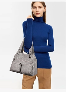 Détails du sac à bandoulière en similicuir gris avec plusieurs poches zippées