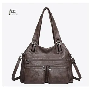 Détail du sac à bandoulière en similicuir marron chameau avec texture grainée et zips en métal