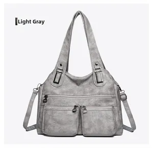 Détail du sac à bandoulière en similicuir gris clair avec plusieurs fermetures éclair