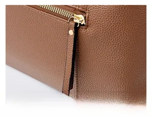 Dettaglio macro della borsa in pelle litchi marrone con cerniera in metallo dorato premium