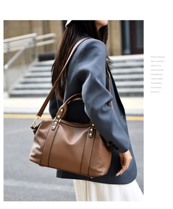 Dettaglio della pelle martellata marrone e degli accessori dorati sulla borsa Boston
