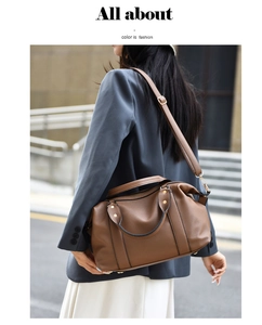 Borsa Boston marrone con trama a grana indossata a tracolla da una modella in strada