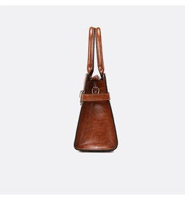 Side view of retro brown embossed shoulder bag with textured leather and D-ring details