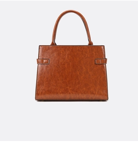 Close-up of vintage brown oil-wax textured handbag with retro leather strap details